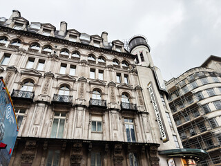 Naklejka premium Historic theatre facade with The Book of Mormon sign on ornate stone building in London, UK showing Victorian architecture and urban streetscape under overcast sky