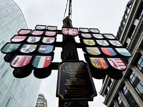 Swiss cantonal coats of arms display on a ceremonial cantonal tree sign in London UK near Westminster showing heraldry and national symbols