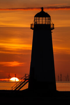 Close up silhouette of Point of Ayr Lighthouse against a fiery sunset