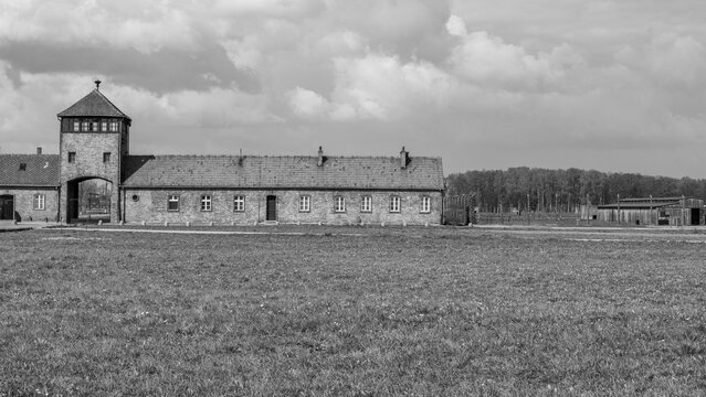 Panoramic black and white view of wooden barracks at Auschwitz II-Birkenau. Wide landscape of the former extermination camp with watchtowers. Oswiecim, Poland - April 21, 2026.