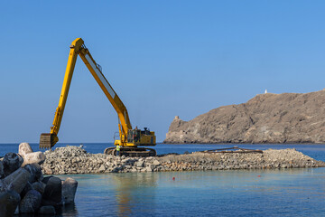 Marine construction for new artificial islands featuring heavy excavator, coastal engineering and waterfront land development near shoreline © Ekaterina Elagina