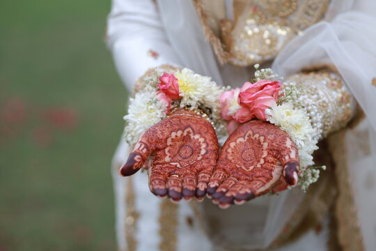 Bride Showing Mehndi Henna Design on Palms with Floral Hand Jewelry