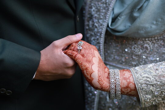 Wedding Couple Holding Hands with Mehndi and Ring at Pakistani Ceremony