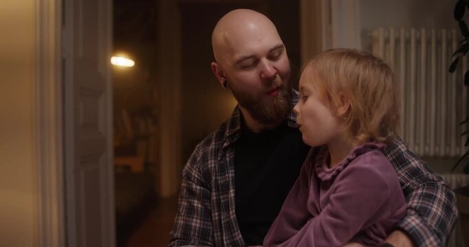 A delightful exchange of smiles and giggles unfolds as a father shares a cozy evening with his daughter at home