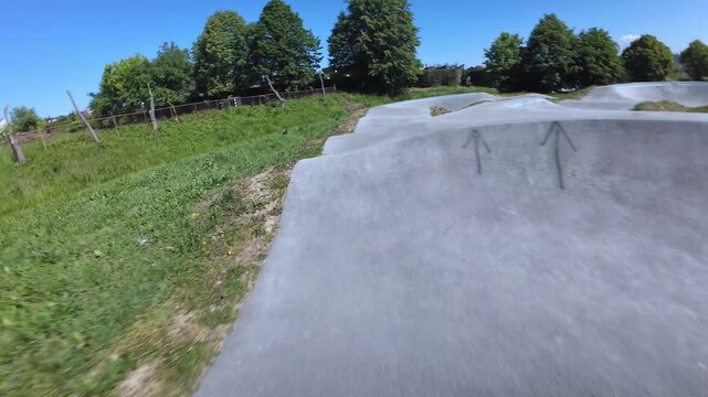 ​Athletic Adult Man Wearing Protective Gear and Helmet Enjoying Inline Skating and Rollerblading Action on a Sunny Asphalt Pump Track at Zabok, Croatia