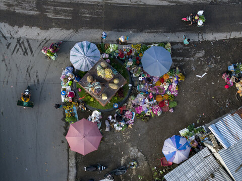 Aerial view of Pasar Kembang Klaten traditional market with colorful umbrellas, fresh produce, and vendors Klaten, Central Java, Indonesia.