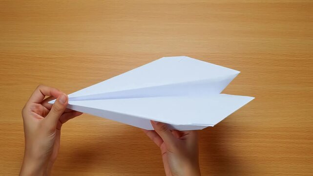 Hands holding a paper airplane ideal for sleek commercial backgrounds and title sequences