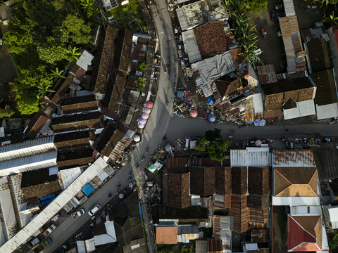 Aerial view of Pasar Kembang Klaten traditional market with densely packed rooftops, winding roads, and colorful stalls in Klaten, Central Java, Indonesia.