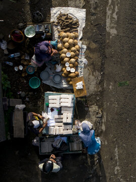 Aerial view of vendors selling tempeh, coconuts, and root vegetables at Pasar Kembang Klaten traditional market in Kemalang, Central Java, Indonesia.
