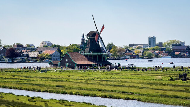Traditional Dutch windmills at Zaanse Schans, a historic open-air village in the Netherlands, featuring green wooden houses, canals, and scenic countryside.