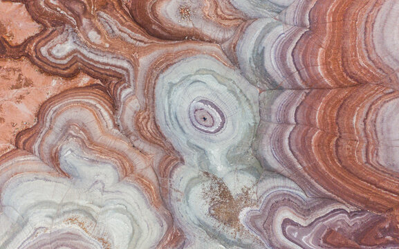 Aerial view of man laying on rock formations in Hanksville, Utah, USA.
