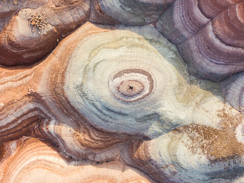 Aerial view of man laying on rock formations in Hanksville, Utah, USA.