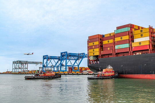 Boston, MA, US-April 25, 2026: Large international cargo ships in harbor  loaded with shipping containers.
