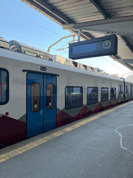 Modern train car parked at train station under clock display