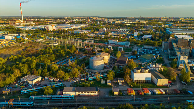 Aerial view of Malesice Infrastructure Objects featuring industrial tanks, cooling towers, and blue trains on railway tracks in Hlavni mesto Praha, Hlavni mesto Praha, Czechia.
