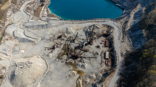 Aerial view of Tomkins Cove quarry featuring industrial machinery, large gravel piles, and a vibrant blue lake Stony Point, New York, United States.