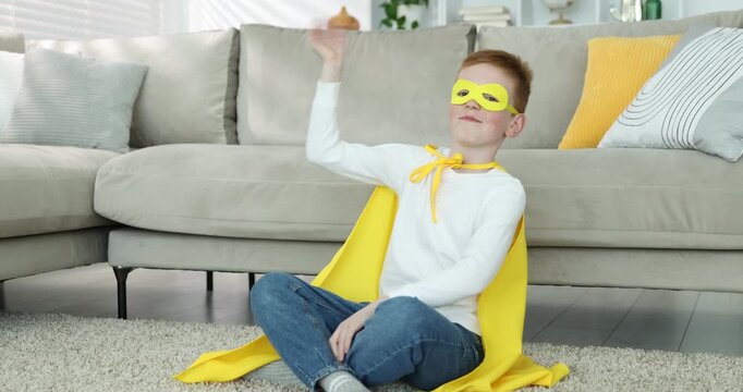 Little boy in superhero costume at home