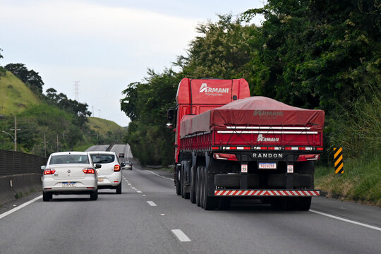 RESENDE, BRAZIL - MAIO 9: A red semi-truck carrying cargo under a tarp travels along a multi-lane