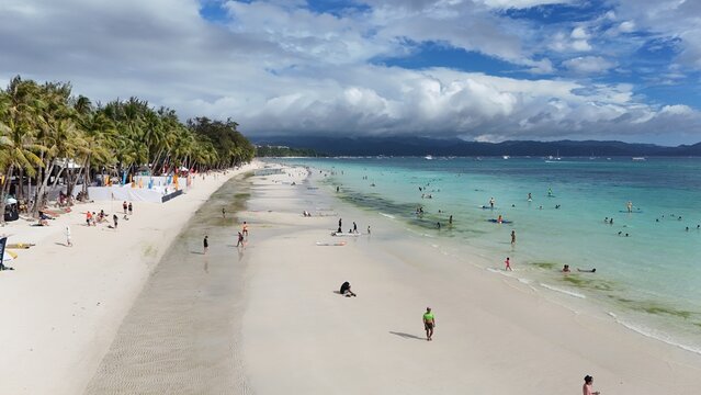 Malay, Philippines - 02 May 2026: Aerial view of Boracay Island with its white sand beach, turquoise waters, and palm trees under a cloudy sky.