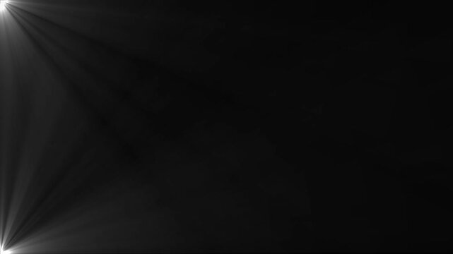 A dark background is illuminated by bright white light rays emanating from the bottom left corner, creating a dramatic lens flare effect with soft, diffused beams of light spreading across the