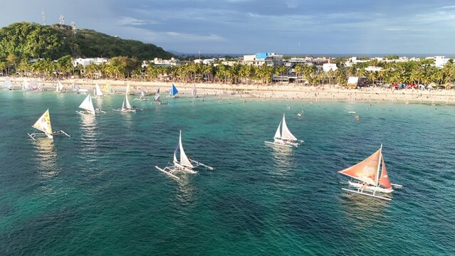 Malay, Philippines - 02 May 2026: Aerial view of Boracay Island with traditional paraw sailboats on turquoise water along the white sand beach and palm trees.
