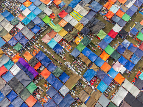 Tongi, Bangladesh - 31 January 2025: Aerial view of thousands of pilgrims gathered under a sea of vibrant, multi-colored tarps during the Bishwa Ijtema religious congregation.