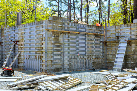 Construction site progress on new building structure in forested area