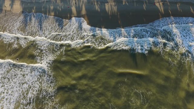 Vietnam, Da Nang Foamy Waves Crashing On Shore, Close Aerial View Of Turbulent Surf And White Foam Lines, Emerald Water Meeting Wet Sand, Long Human Shadows On Beach Edge, Rhythmic Tide