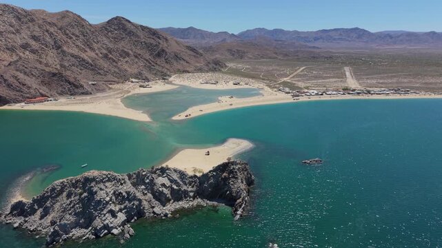 Aerial views show an SUV parked with a teardrop trailer while camping on a remote island in Punta Final, Gonzaga Bay, Baja California, Mexico.