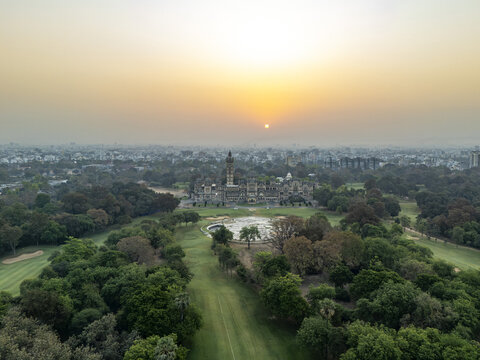 Vadodara, India - 14 March 2026: Aerial view of Laxmi Vilas Palace with its Indo-Saracenic architecture surrounded by lush green grounds and a hazy sunset over the city skyline.