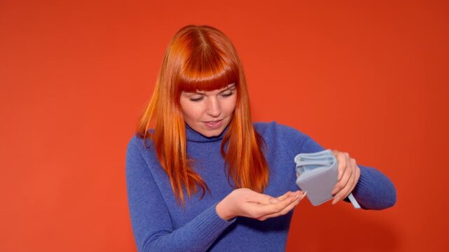 Examining a wallet and showing its contents in front of a plain background