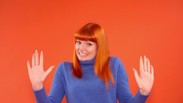 Person shows different expressions with smiles and gestures in a bright orange background setting
