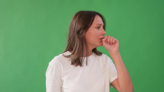 Woman showing emotions, such as coughing in front of a green background  