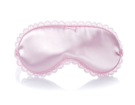 Satin sleep mask with decorative scalloped trim isolated on white background