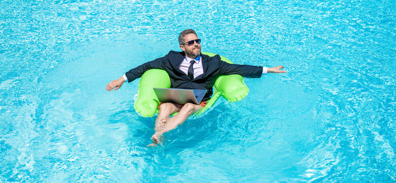 Remote working. Summer business vacation. Funny crazy businessman rest in formal wear in pool. Businessman in suit with laptop in swimming pool. Crazy business man summer vacation. Laptop outdoors