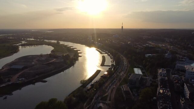 Nederrijn in Arnhem Gelderland Netherlands forms meander with industrial harbor basin and quay infrastructure near Kleefse Waard while KEMA Tower rises on skyline as drone flies forward