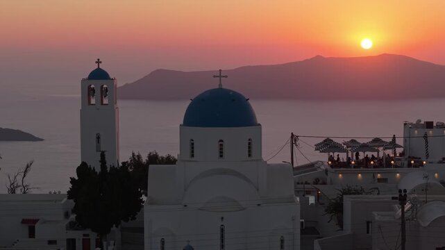 Drone Orbit of Picturesque Santorini Chapel Revealing SunsetDrone orbiting a picturesque Santorini chapel, revealing the sunset over the caldera, dramatic cliffs, and the deep blue Aegean Sea