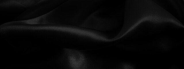 Fototapeta premium Black fabric background. Cloth wavy texture