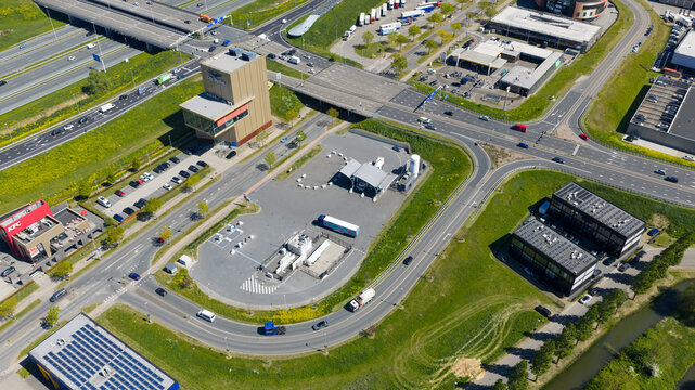 Utrecht, Netherlands - 29 April 2026: Aerial view of the LNG and hydrogen Tankstation Rolande featuring fuel pumps and designated parking spaces next to a busy road with passing vehicles.