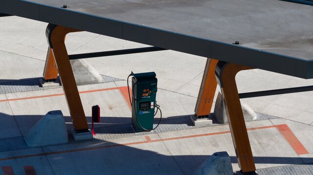 Zwolle, Netherlands - 23 April 2026: Aerial view of the Milence Charging Hub Zwolle featuring a modern wooden canopy structure and an electric vehicle charging station on a concrete pavement.