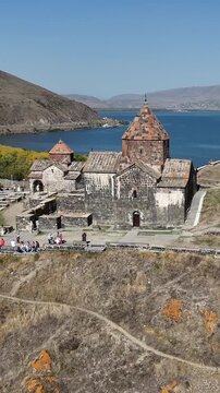 Drone shot of monastery, Lake Sevan shoreline and hills, Armenia