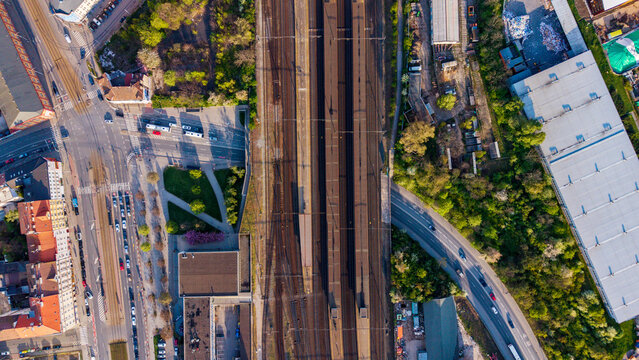 Praha, Czechia - 21 April 2026: Aerial view of a marshalling yard with railway tracks, platforms, and surrounding urban streets with traffic and green trees.
