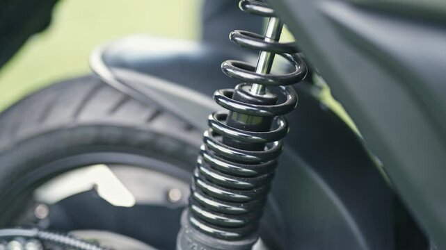 Close-up of an electric scooter shock absorber, highlighting suspension system, spring mechanism, and ride comfort technology in modern mobility.