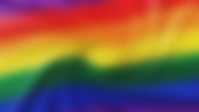Rainbow flag fabric waving gently with soft light celebrating Pride Month awareness and diversity