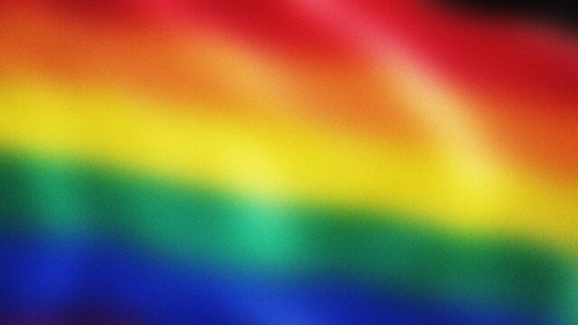 Rainbow flag waving gently during Pride Month celebration with soft focus and vibrant colors celebrating diversity and inclusion