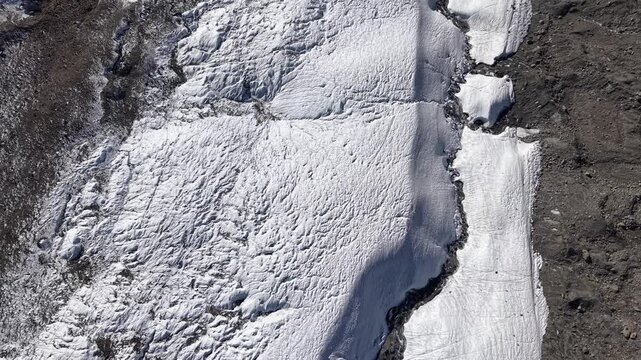 Aerial flyover over the Gorner glacier at Gornergrat in Zermatt, Switzerland with a pan up view from the icy crevasses up to the famous Matterhorn on a autumn day in the Swiss Alps