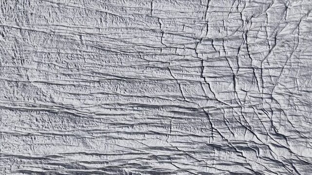 Aerial flyover above the Gorner glacier at Gornergrat in Zermatt, Switzerland with a pan up view from the icy crevasses up to the famous Matterhorn