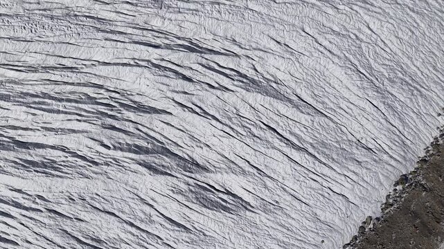 Aerial flyover over the Gorner glacier at Gornergrat in Zermatt, Switzerland with a top down view of the icy crevasses