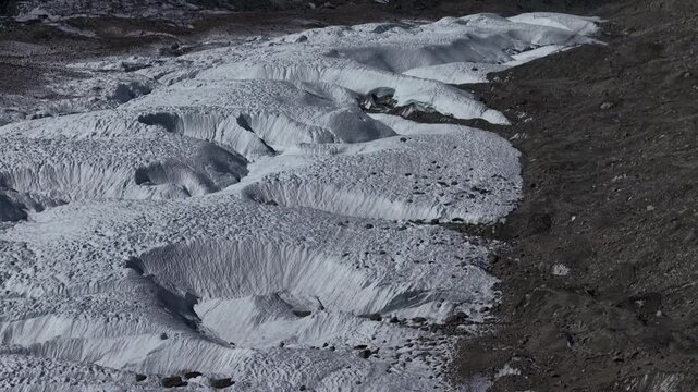 Aerial flyover over the Gorner glacier at Gornergrat in Zermatt, Switzerland with a pan up view from the icy crevasses up to the famous Matterhorn