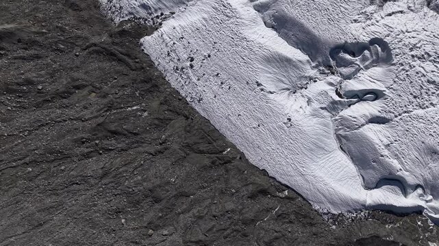 Aerial flyover over the Gorner glacier at Gornergrat in Zermatt, Switzerland with a pan up view from the icy crevasses up to the Dufourspitze, the tallest mountain in the Swiss Alps.